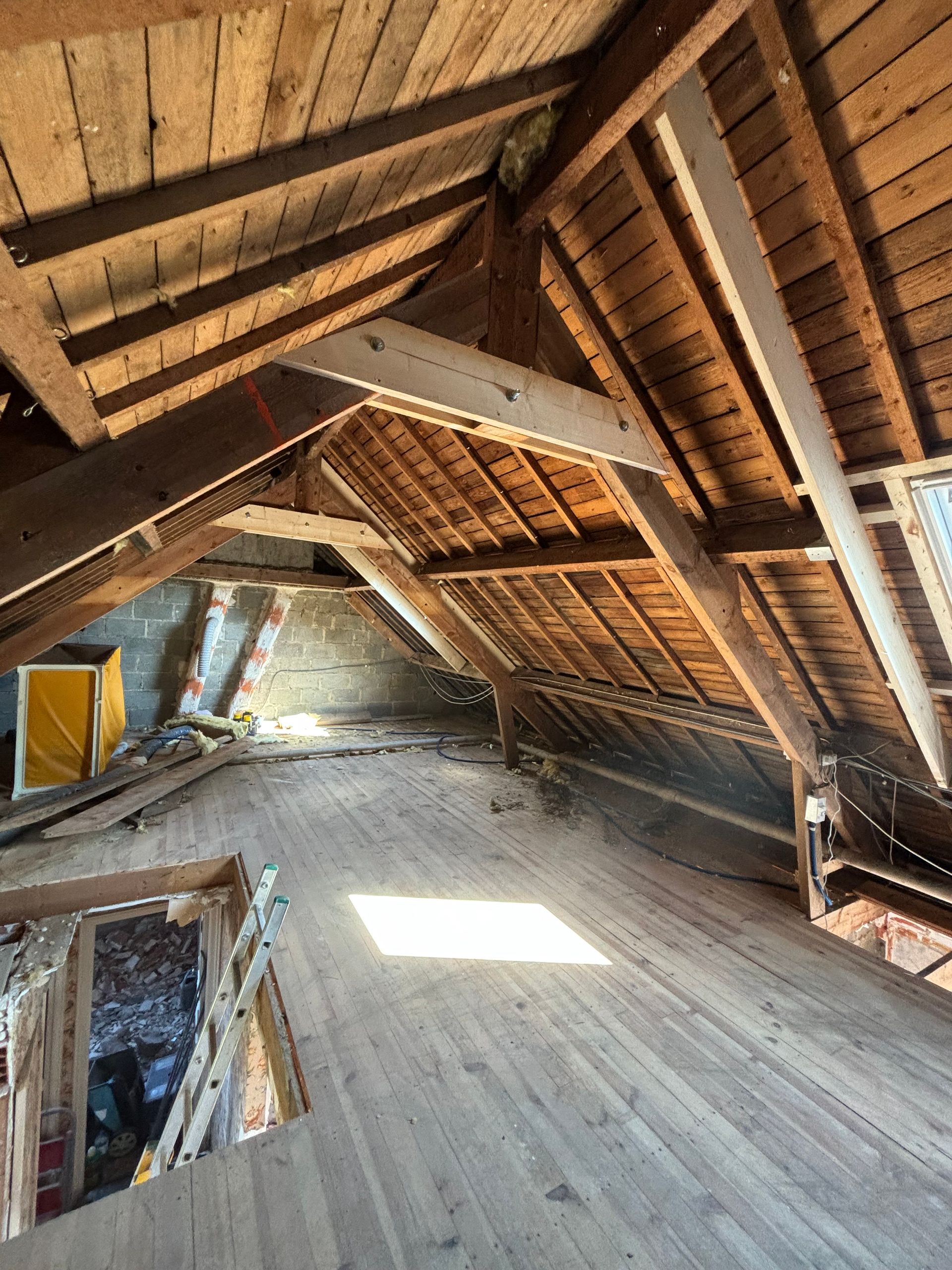 Intérieur d'un grenier avec charpente et poutres apparentes