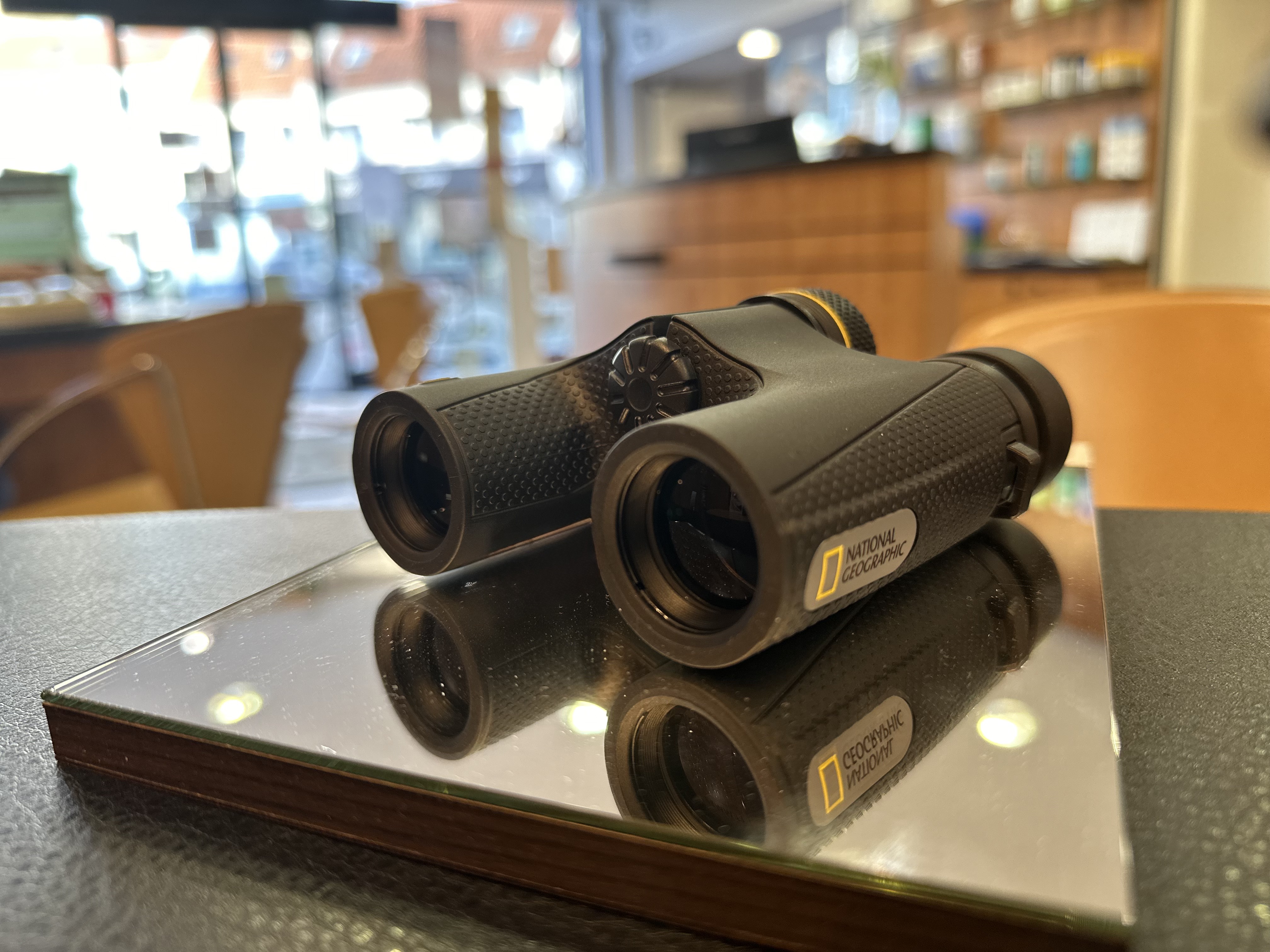 Un homme regarde à travers des jumelles montées sur un trépied.