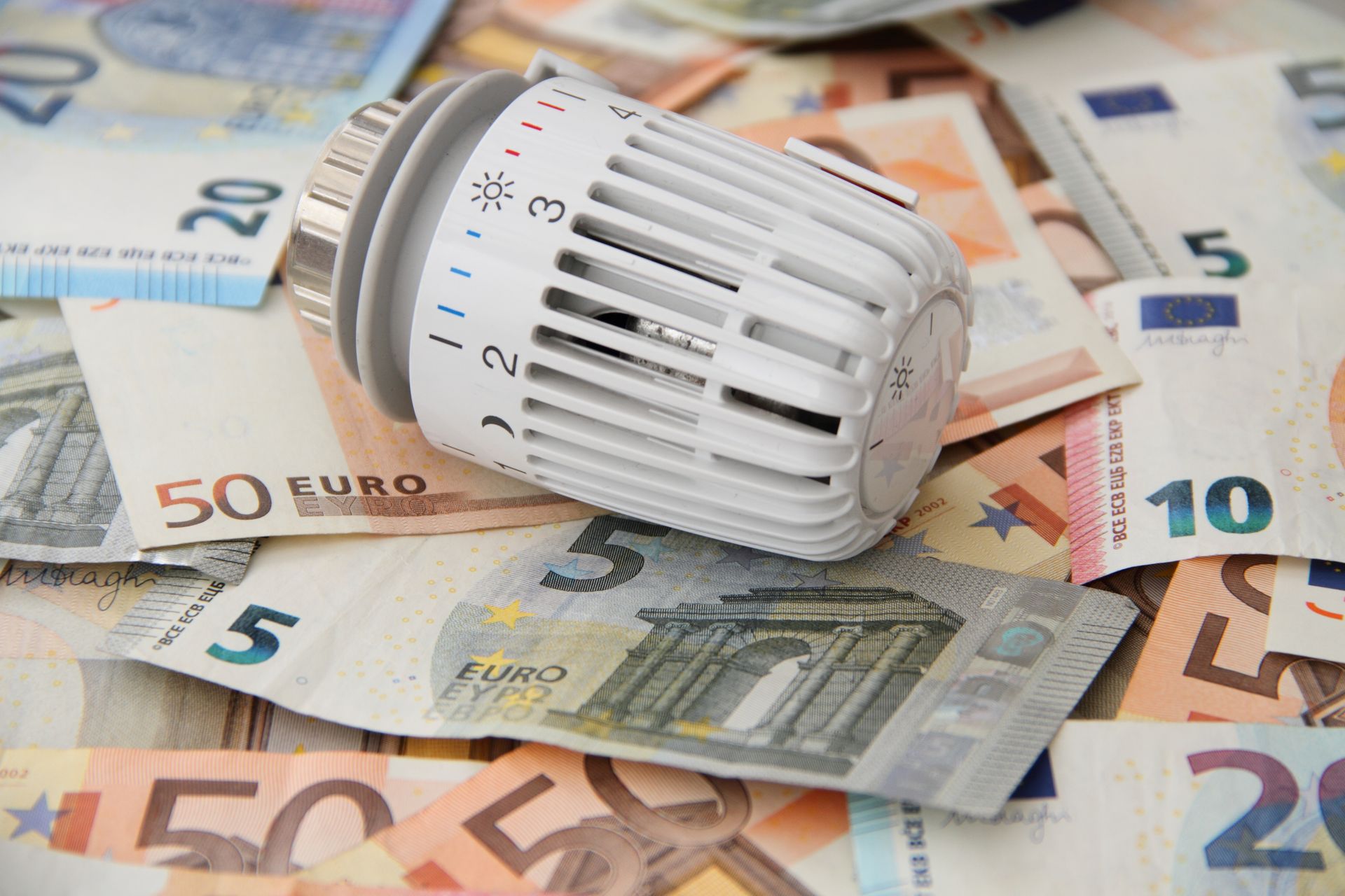 Ein Thermostat liegt auf einem Stapel Euroscheine