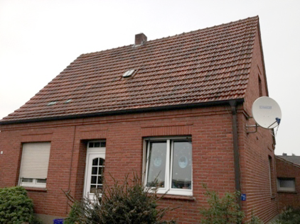 Ein Backsteinhaus mit einer Satellitenschüssel an der Seite