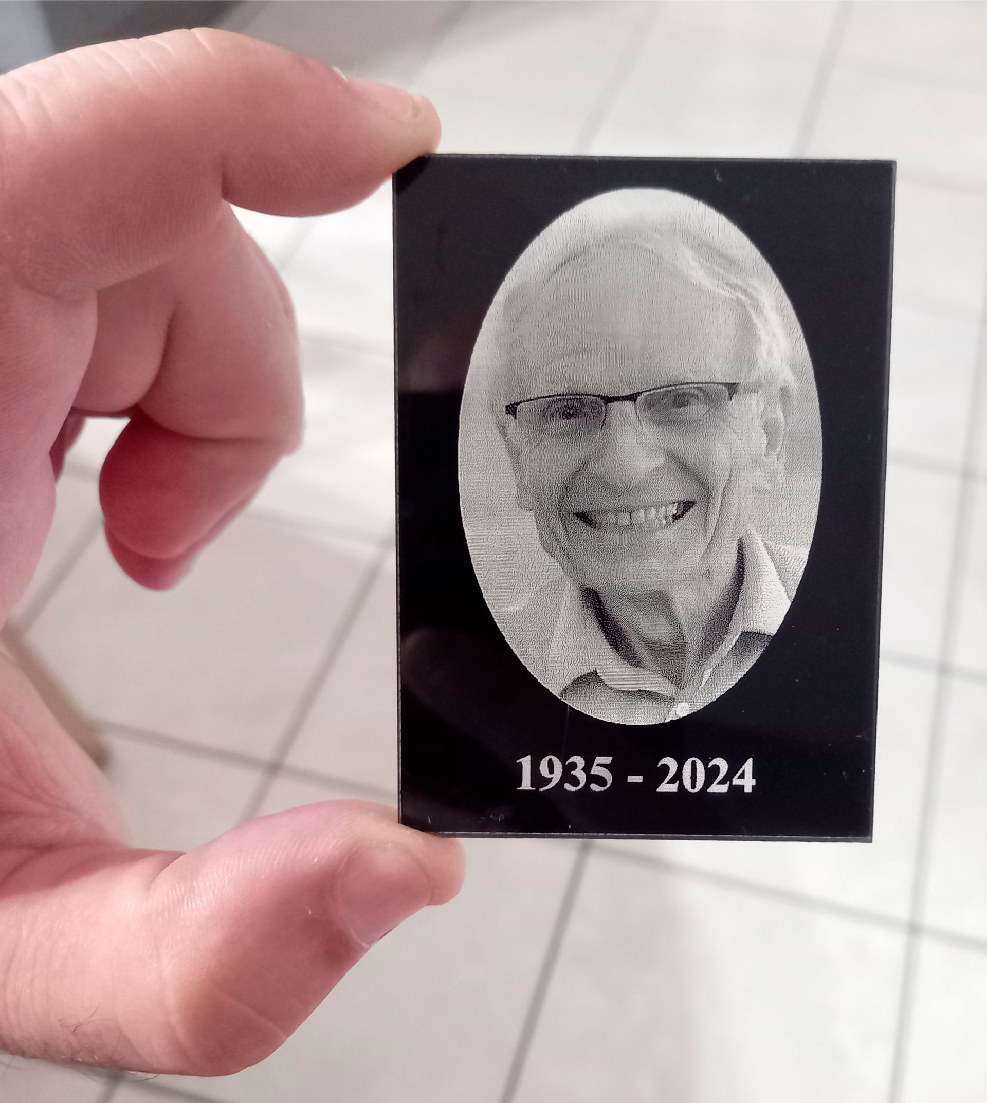 Photographie d'une personne gravée sur un carreau noir