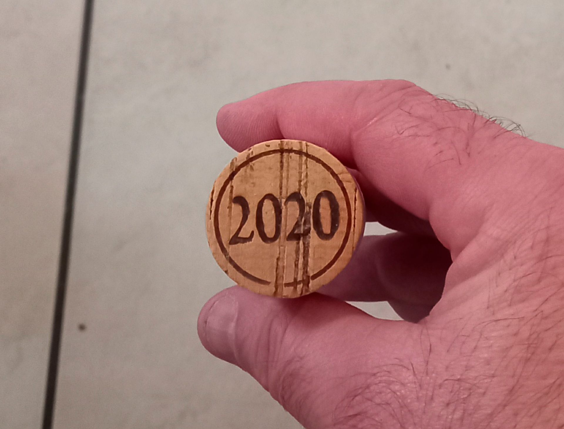Main tenant un bouchon de vin estampillé avec l'année 2020