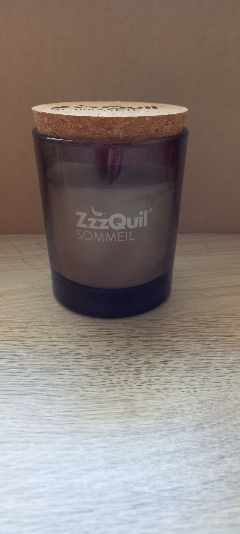 Une bougie ZzzQuil dans un verre foncé