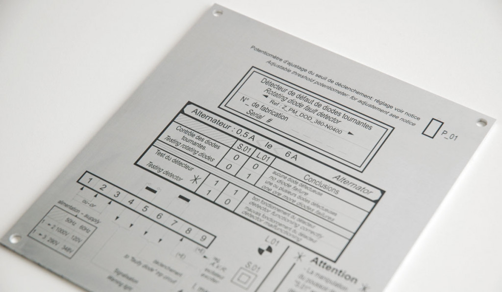 Plaque en métal argenté avec texte gravé et schémas