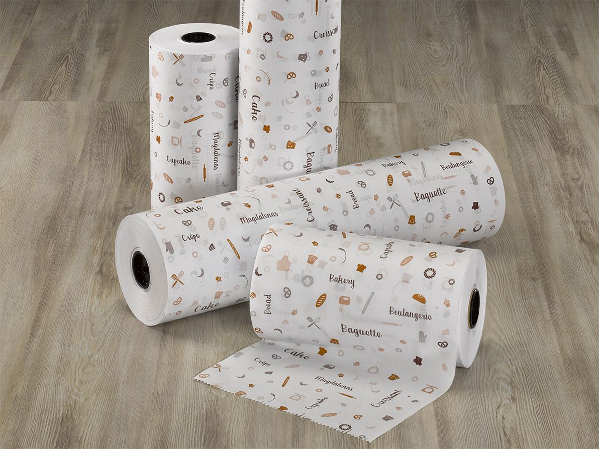 Cuatro rollos de toallas de papel están apilados uno encima del otro sobre un piso de madera.