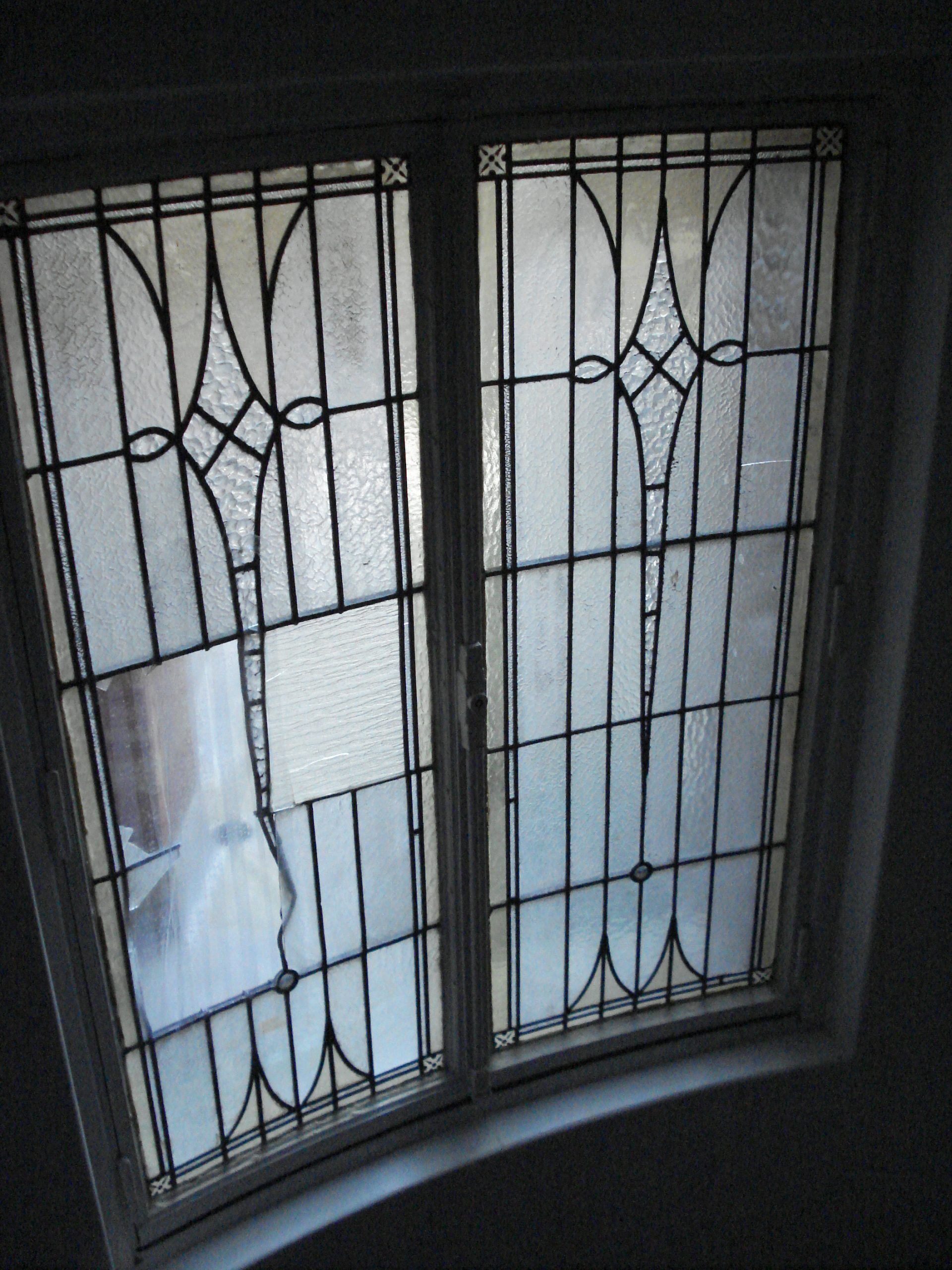 Fenêtre à deux panneaux dépoli avec barres décoratives en métal noir.