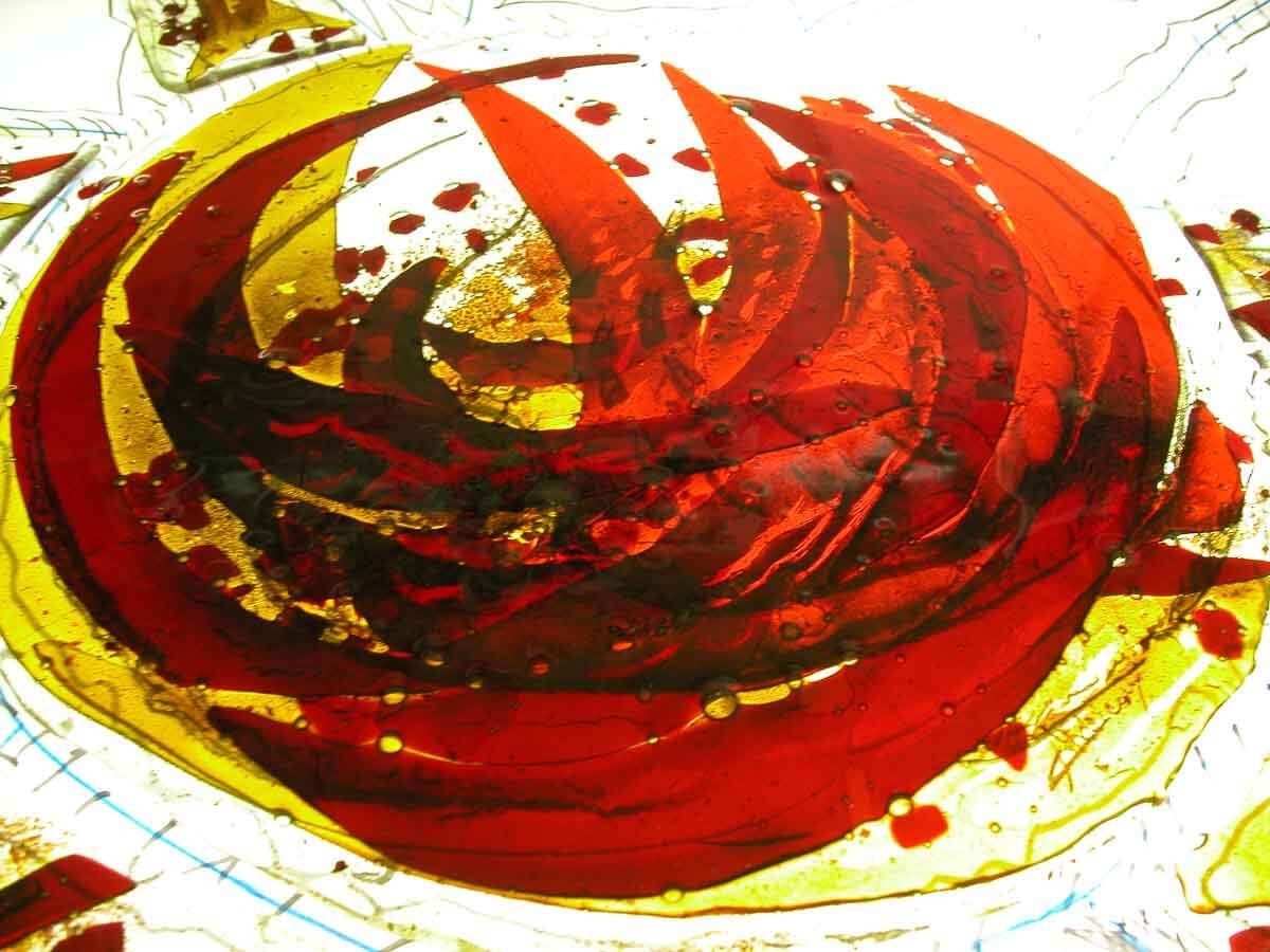 Une œuvre d'art abstraite aux tourbillons rouges et jaunes, évoquant des flammes, inscrite dans un cadre circulaire.