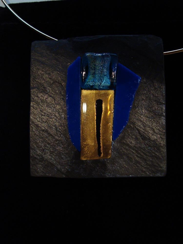 Pendentif abstrait avec des formes dorées et turquoise sur fond bleu et gris carré.