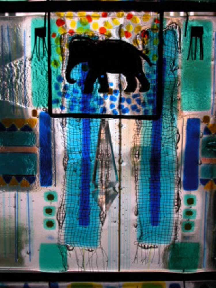 Vitrail représentant la silhouette d'un éléphant noir, entourée de motifs abstraits bleus, verts et orange.