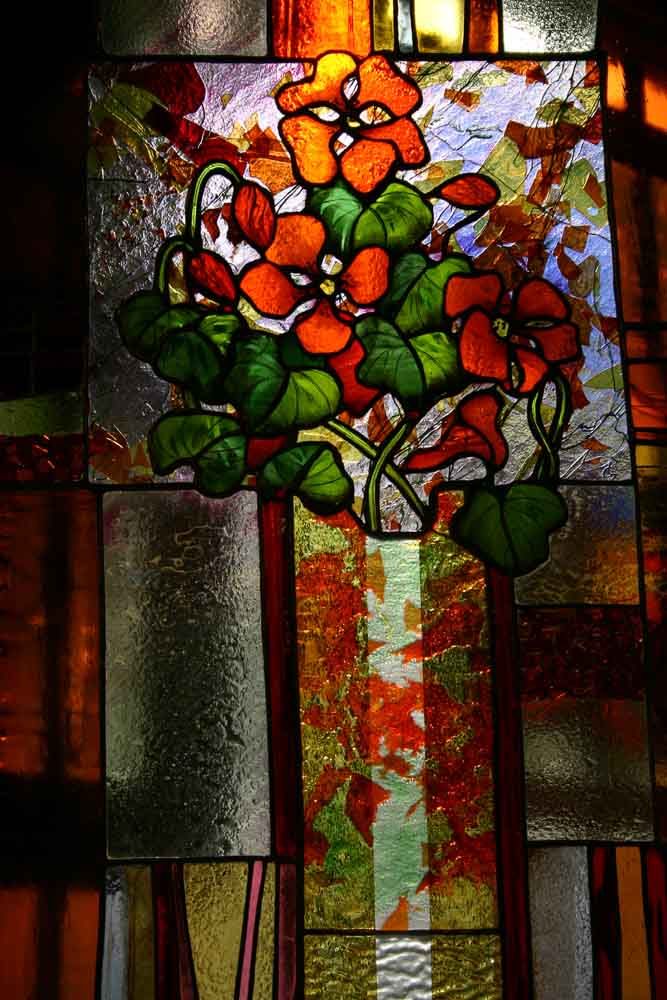 Vitrail : Capucines orange à feuilles vertes sur fond texturé.