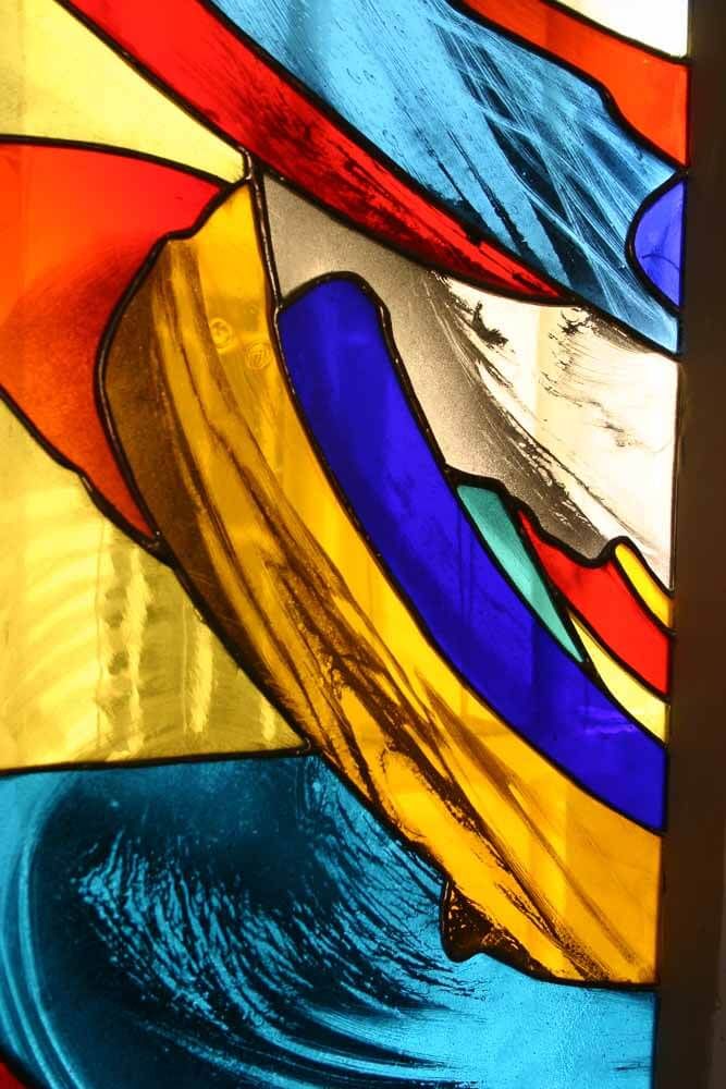 Vitrail abstrait en verre rouge, jaune, bleu et turquoise.