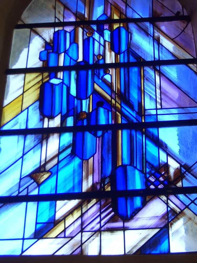 Vitrail orné de formes et de lignes géométriques abstraites bleues et violettes.