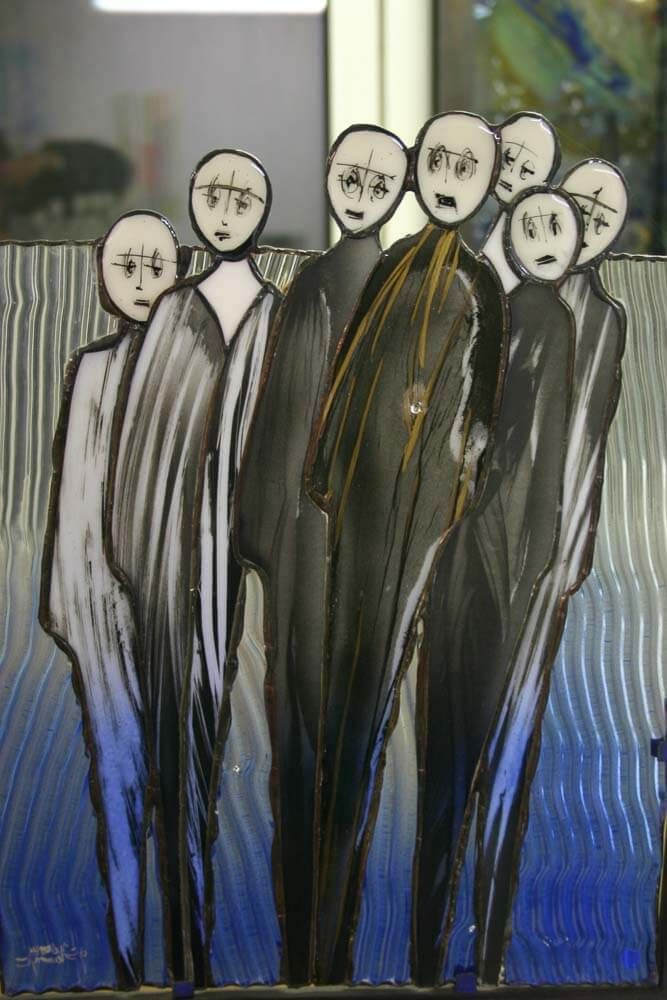 Personnages en vitrail, visages pâles, vêtus de robes sombres et fluides. Fond bleu.