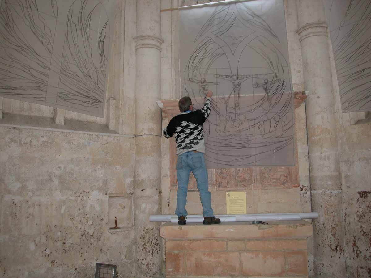 Personne dessinant sur un mur orné d'un motif architectural ; à l'intérieur d'un bâtiment en pierre.