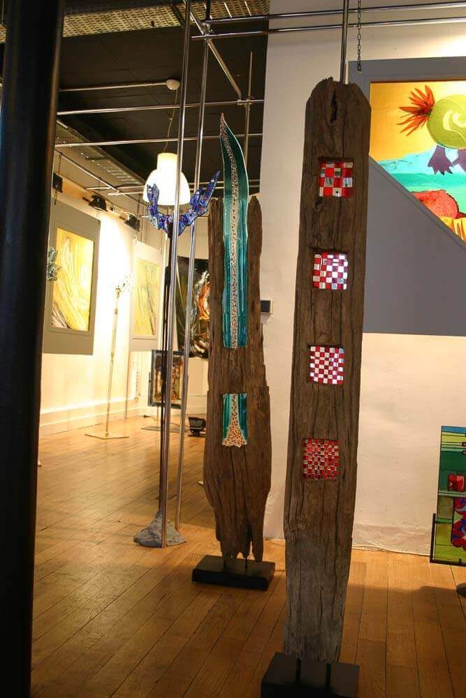 Installation artistique en bois avec du verre et des motifs à carreaux, présentée dans une galerie.
