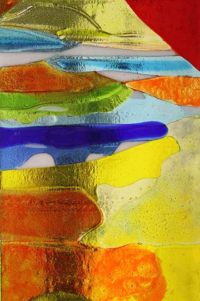 Œuvre en vitrail composée de morceaux de verre colorés, texturés et superposés. Rouge, orange, jaune, bleu et vert.