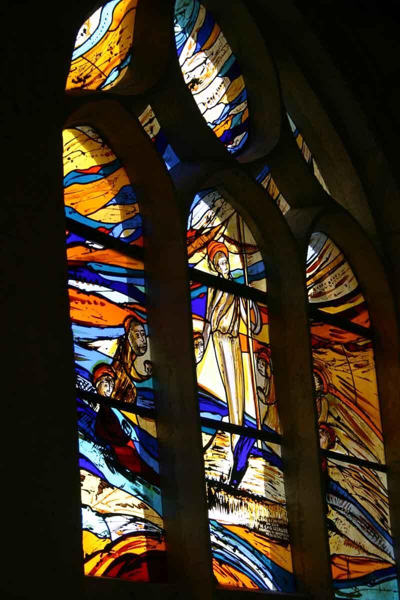 Vitrail aux formes abstraites dans les tons bleus, oranges et jaunes.