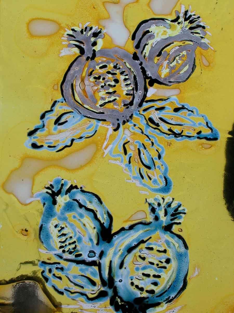 Motifs de grenades, fruits gris et bleus sur fond jaune avec détails de feuilles en vitrail.
