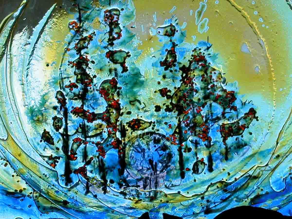 Vitrail abstrait représentant une scène de forêt dans les tons bleus, jaunes et verts.