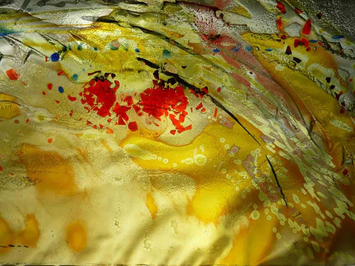 Composition abstraite de peinture jaune, rouge et bleue éclaboussée de traits striés.