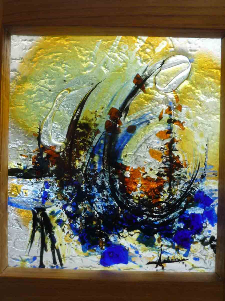 Œuvre d'art abstraite en verre aux tourbillons de bleus, de jaunes et d'oranges ; encadrée de bois.