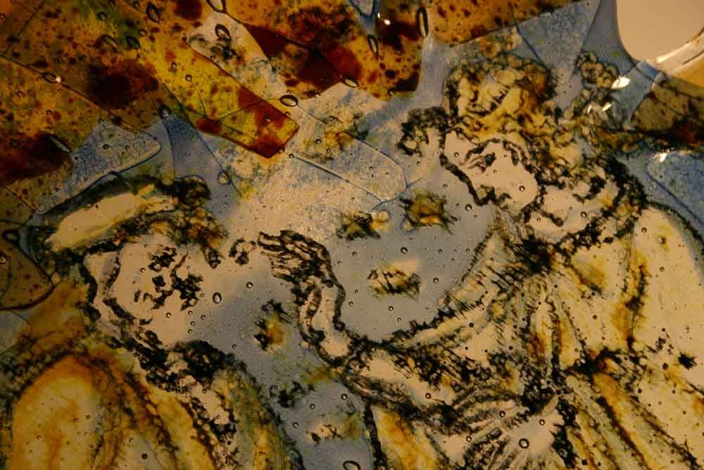 Œuvre fragmentée : Figures aux bras tendus, se détachant sur un fond bleu et brun, évoquant un vitrail.