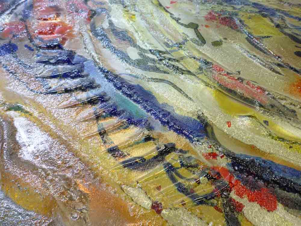 Art abstrait aux couleurs superposées (bleu, jaune, rouge et brun) et à la surface texturée.