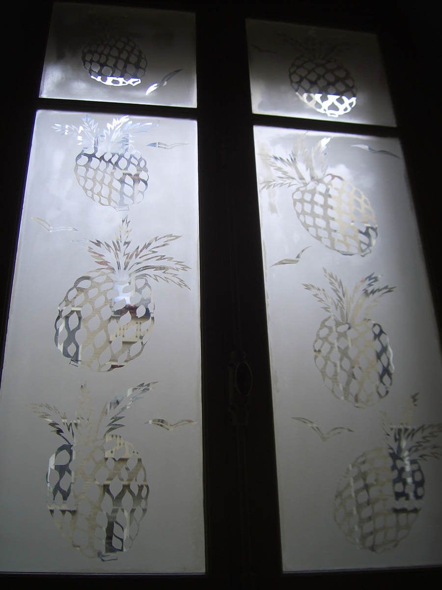 Deux panneaux rectangulaires en verre dépoli gravés de motifs d'ananas.