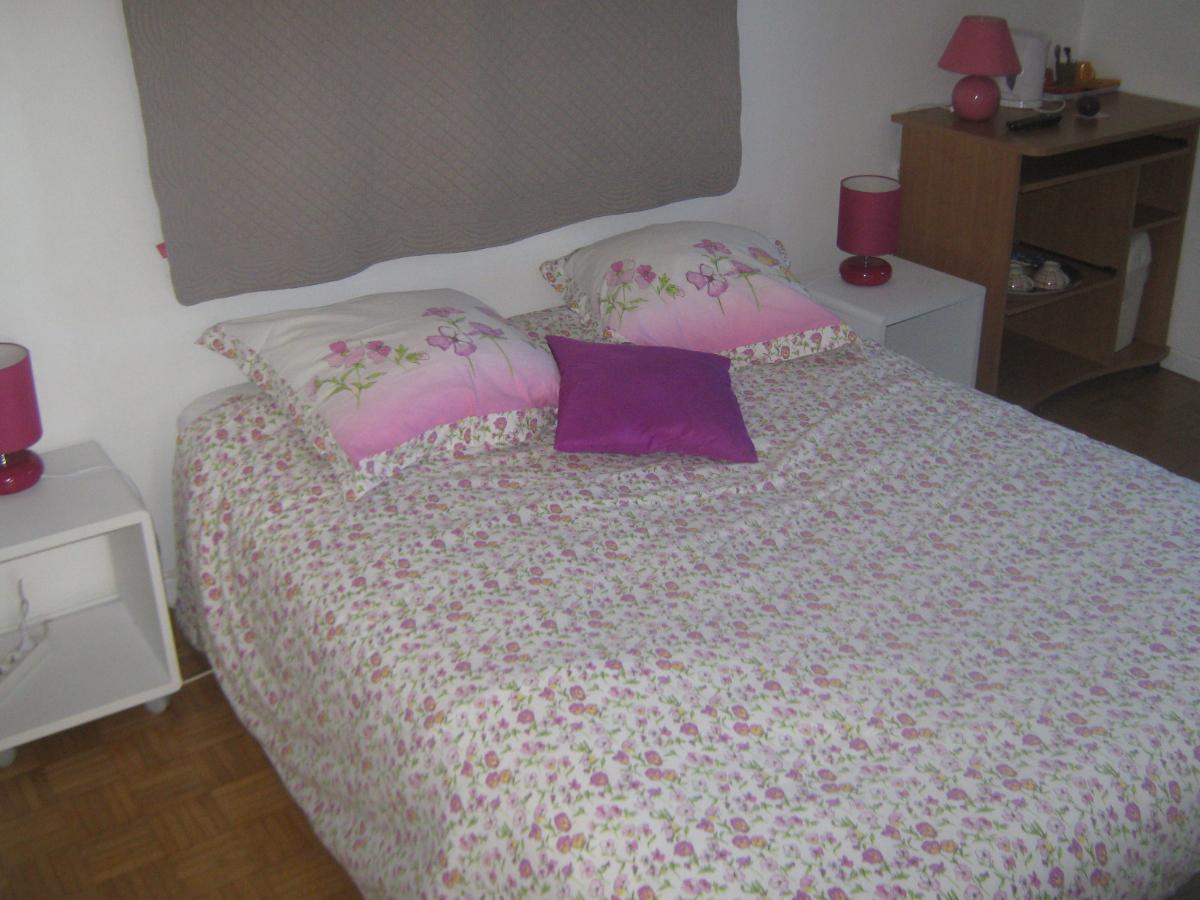 Chambre lit double blanc coussin rose