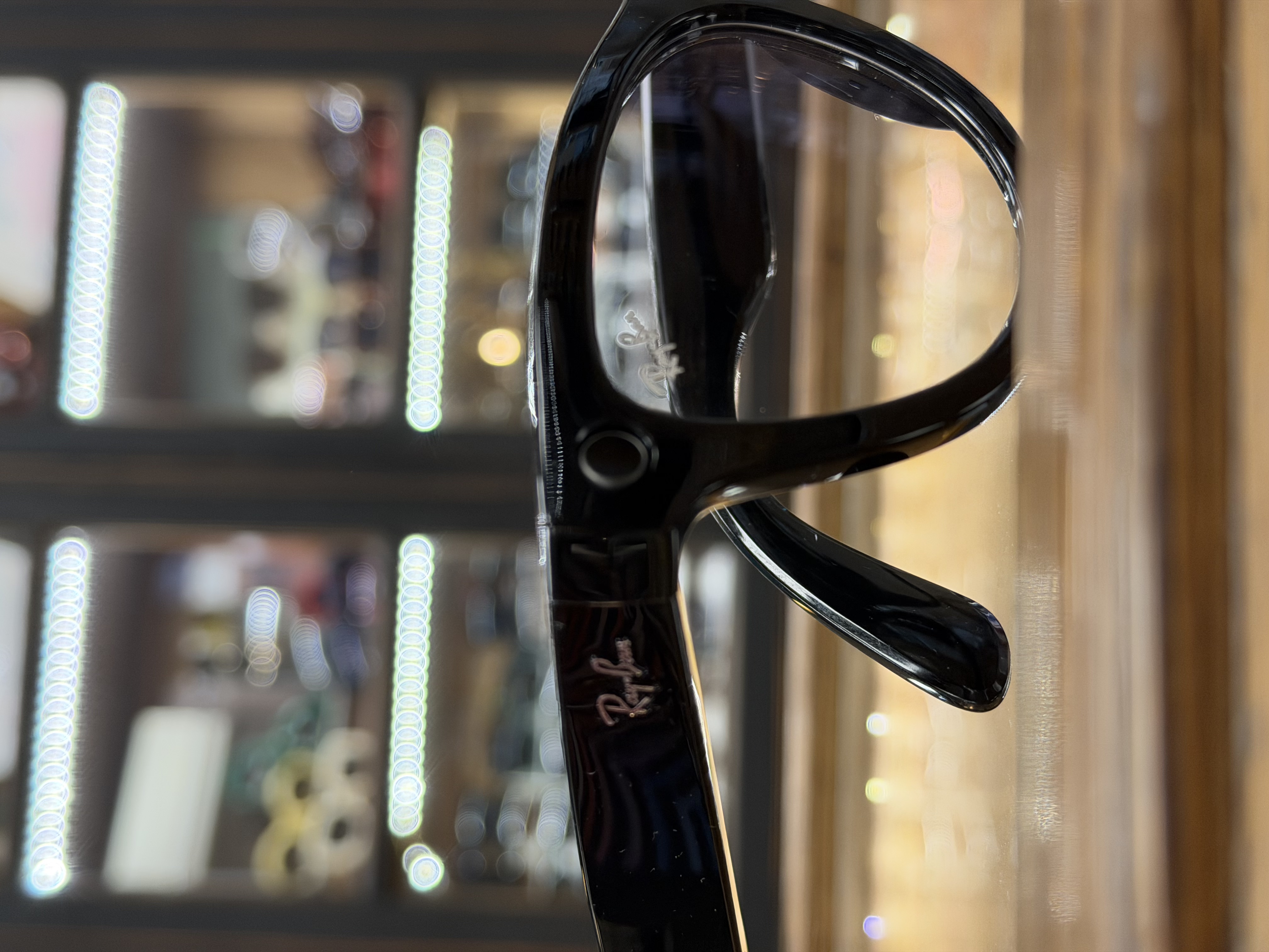 Un homme portant des lunettes de soleil utilisant son téléphone dans une rue.