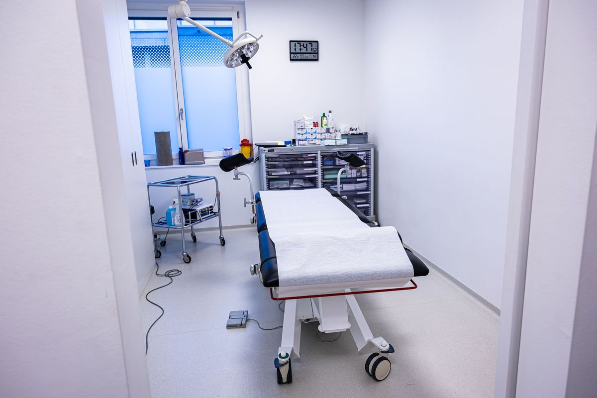 Salle de soins du cabinet avec une table d'examen et un plan de travail