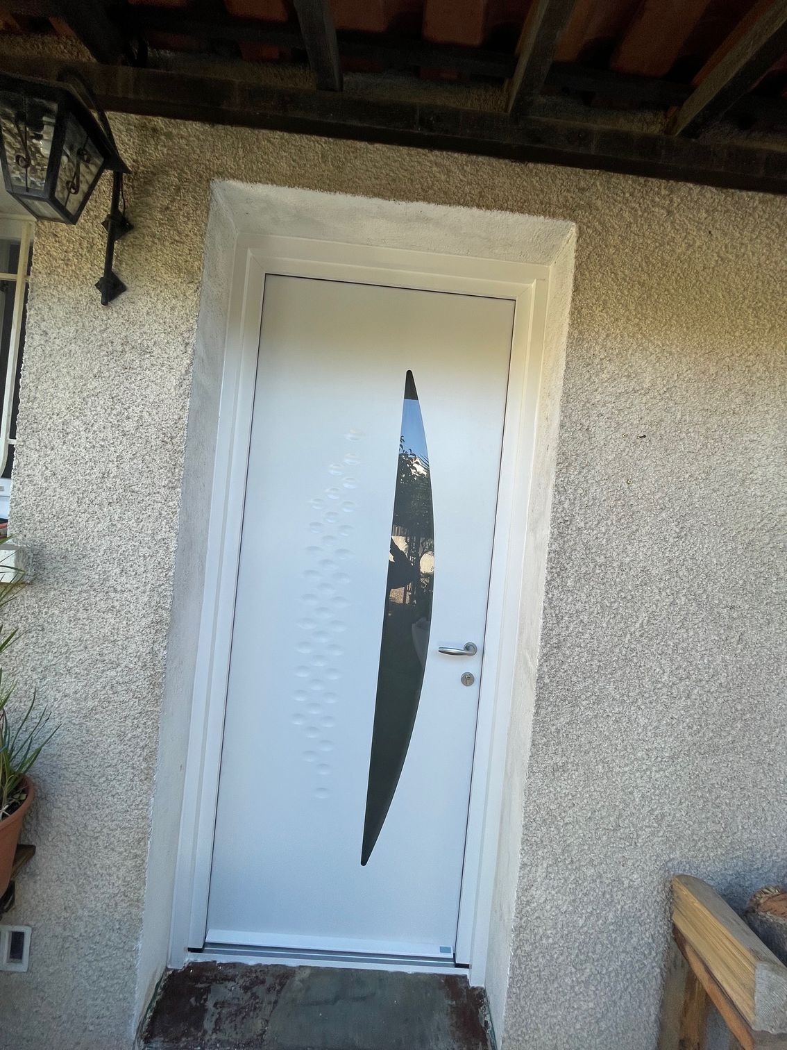 Porte d'entrée blanche avec une vitre en forme de croissant de lune