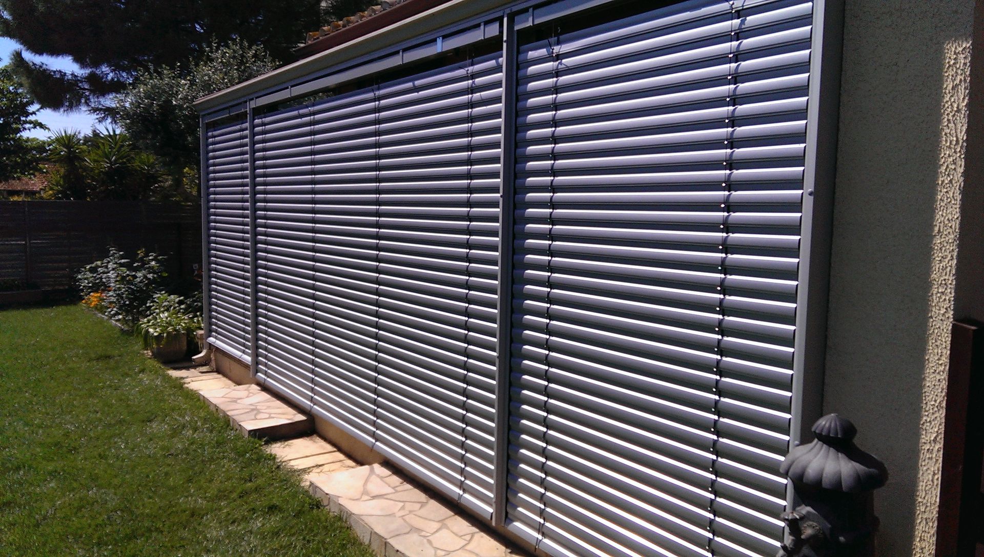 Stores vénitiens fixés à une large baie vitrée