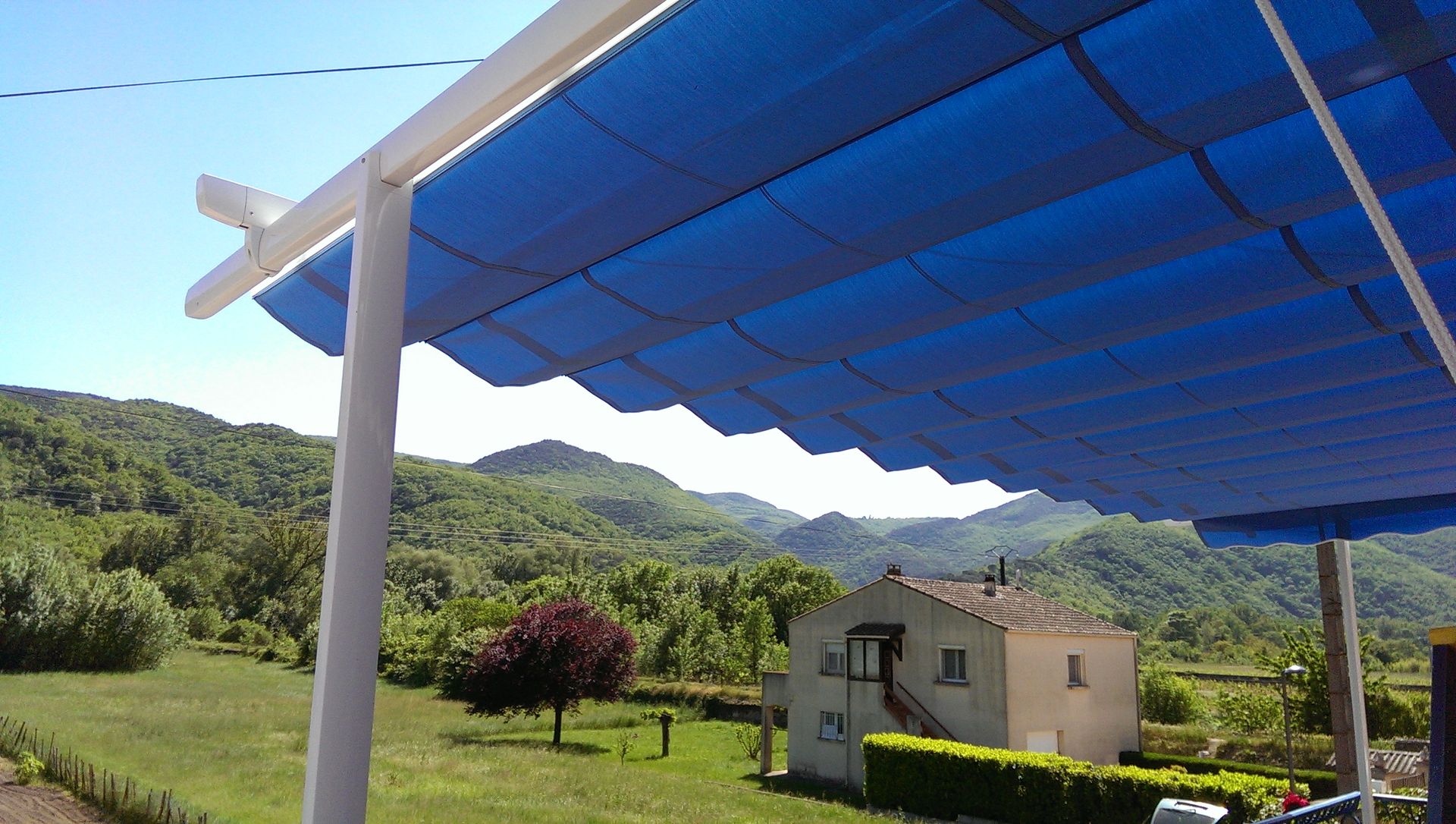 Velum bleu avec en fond un paysage montagneux