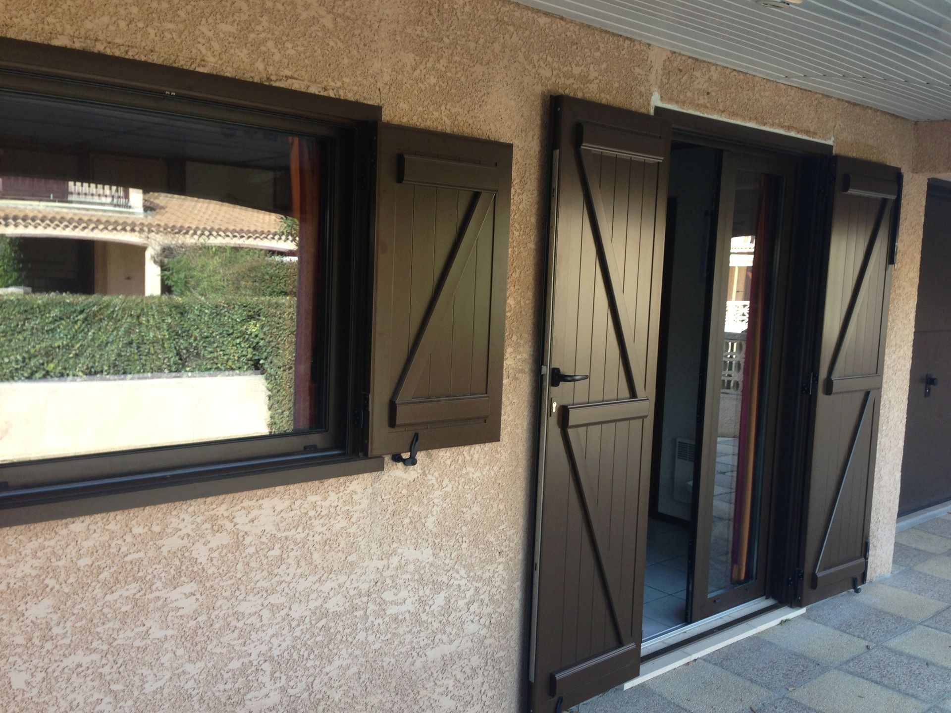 Volets marron foncé de fenêtre et porte vitrée