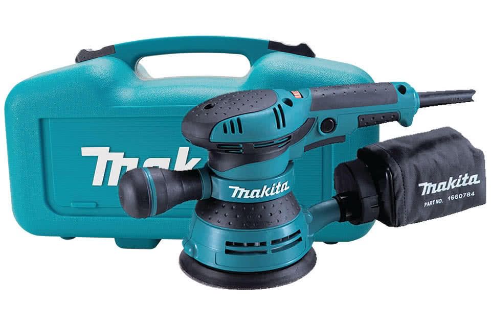 Una levigatrice Makita è in una custodia su uno sfondo bianco.