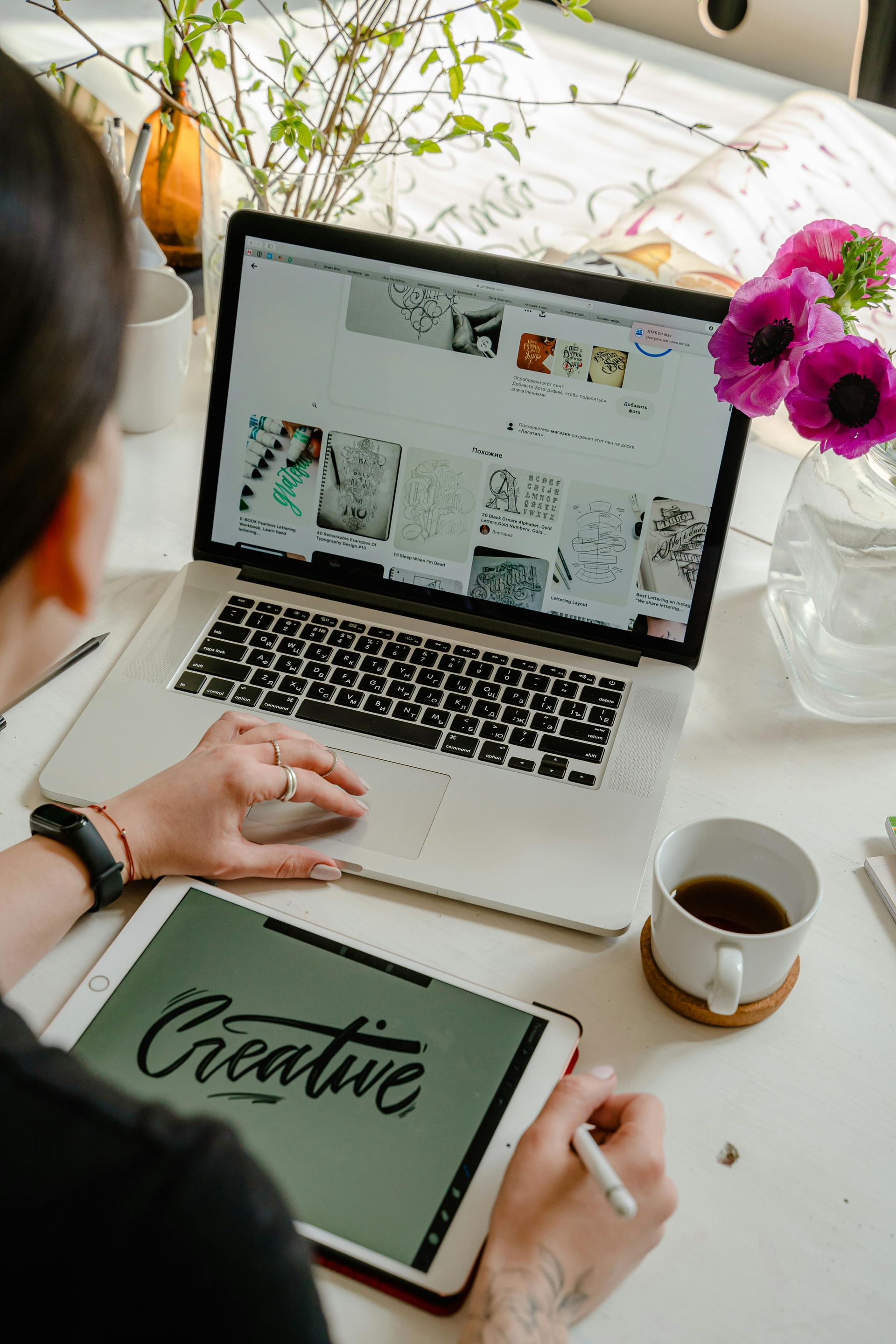 A person using a laptop and a digital tablet with