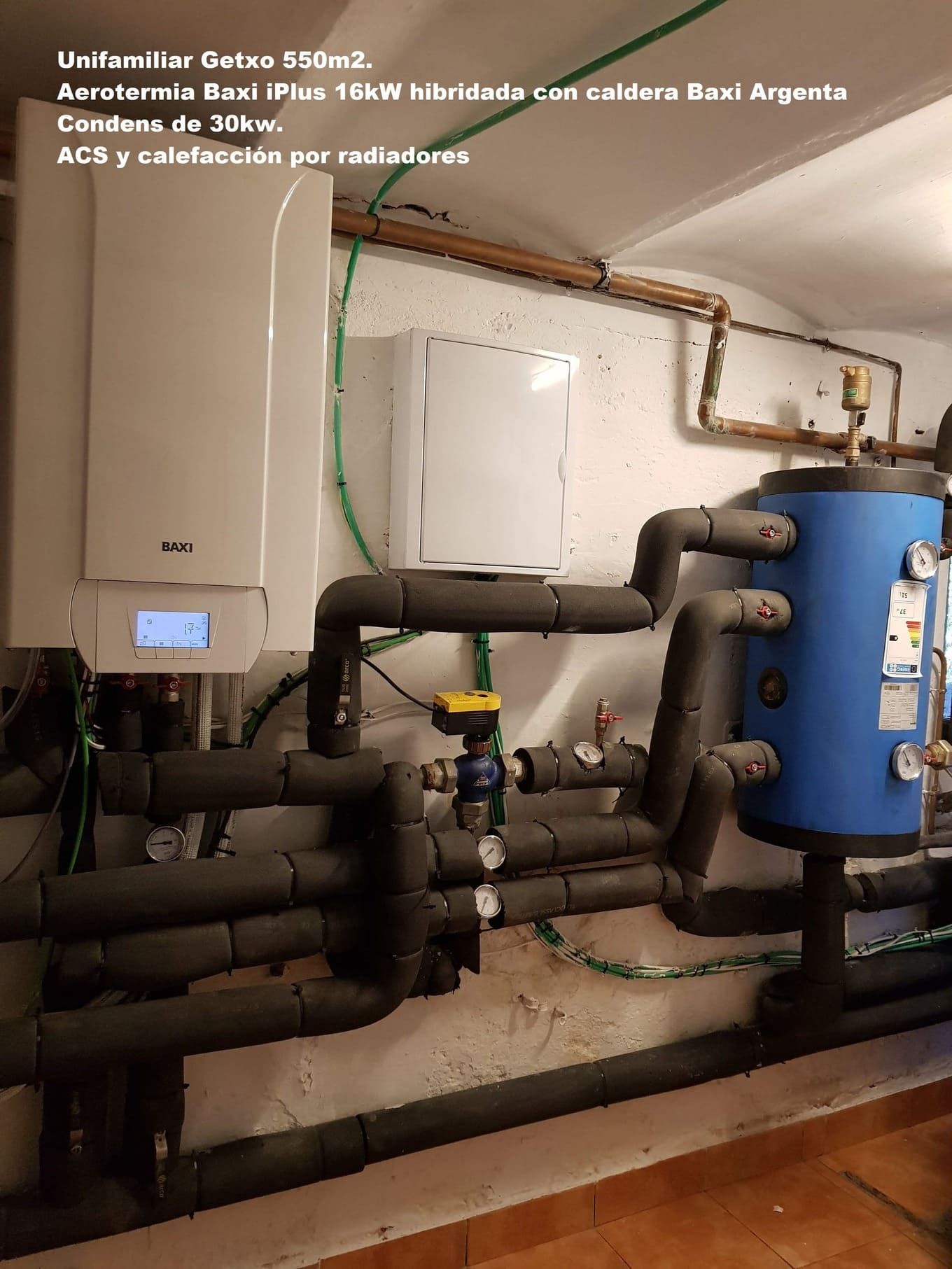 Una habitación con muchas tuberías y un tanque azul.