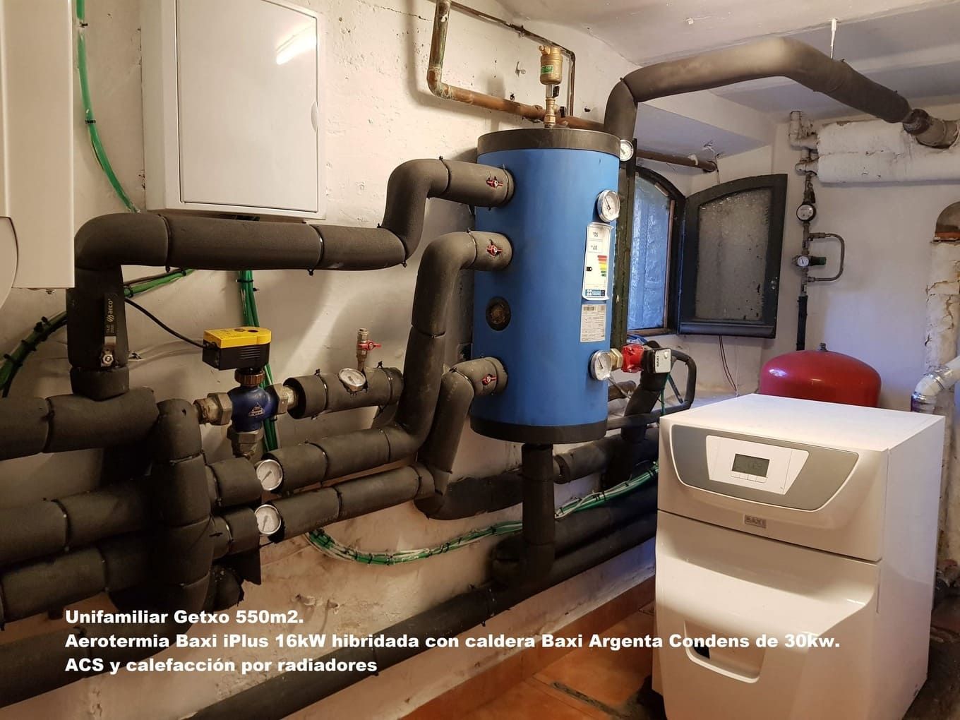 Una habitación con muchas tuberías y un tanque azul.