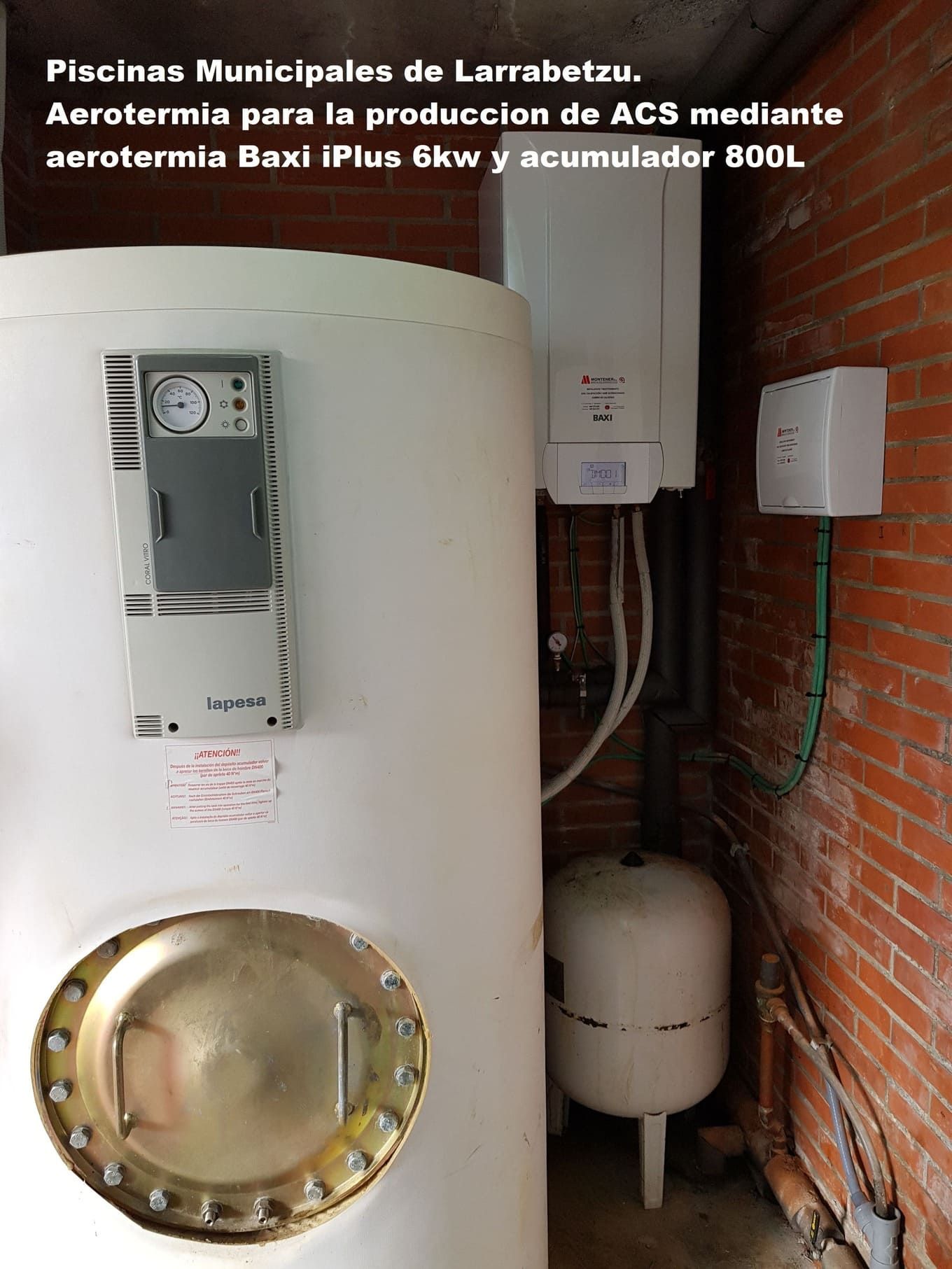 Un calentador de agua blanco está sentado al lado de una pared de ladrillos.