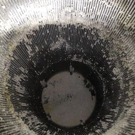 Un primer plano de un recipiente sucio con un agujero en el medio.