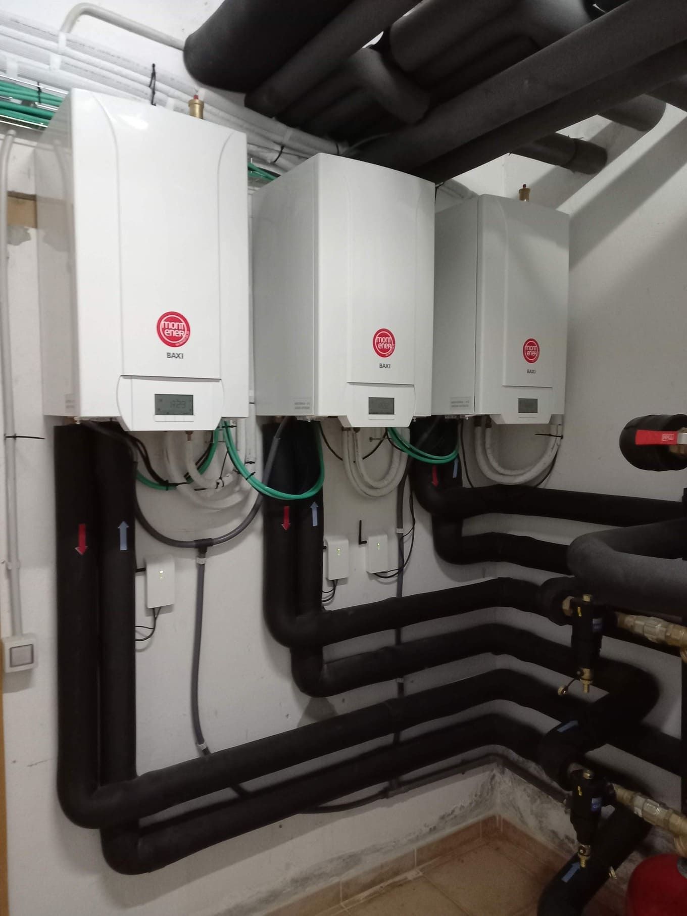 Hay tres calderas blancas una al lado de la otra en una habitación.