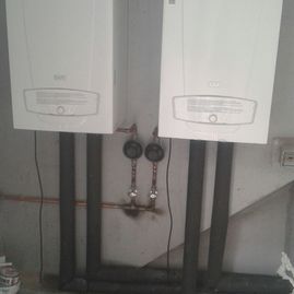 Hay dos calderas blancas una al lado de la otra en una habitación.