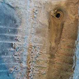 Un primer plano de una pared de ladrillos con un agujero en ella.