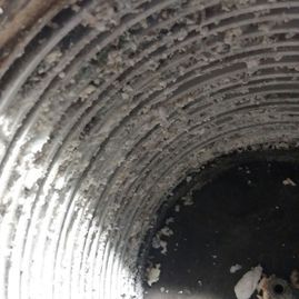 Un primer plano de un conducto sucio con mucho polvo en él.