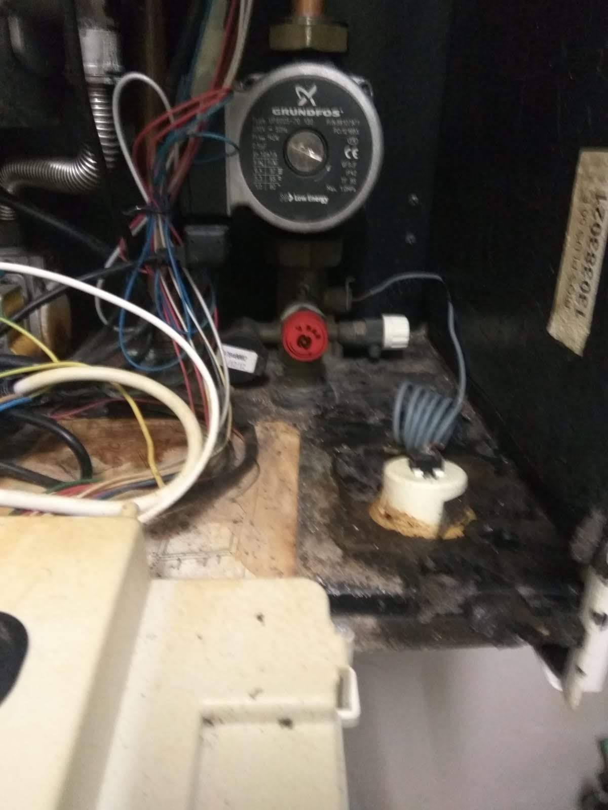 Una bomba de agua está en el suelo al lado de un montón de cables.