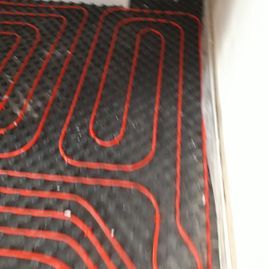 Un primer plano de un sistema de calefacción por suelo radiante rojo y negro.