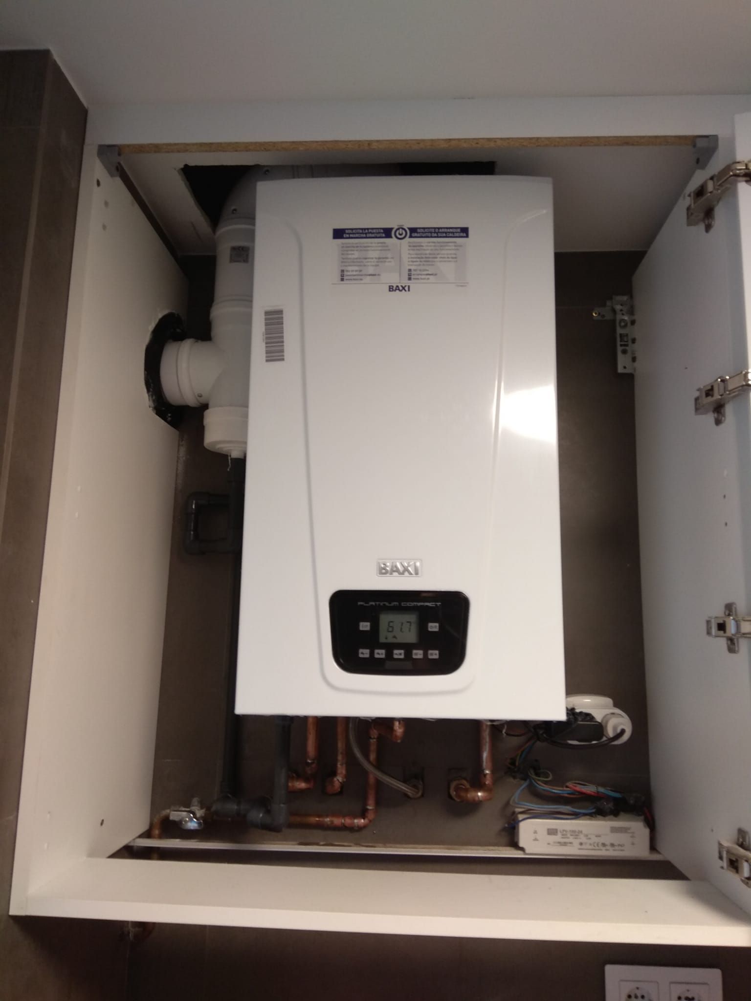 Una caldera blanca está dentro de un armario.