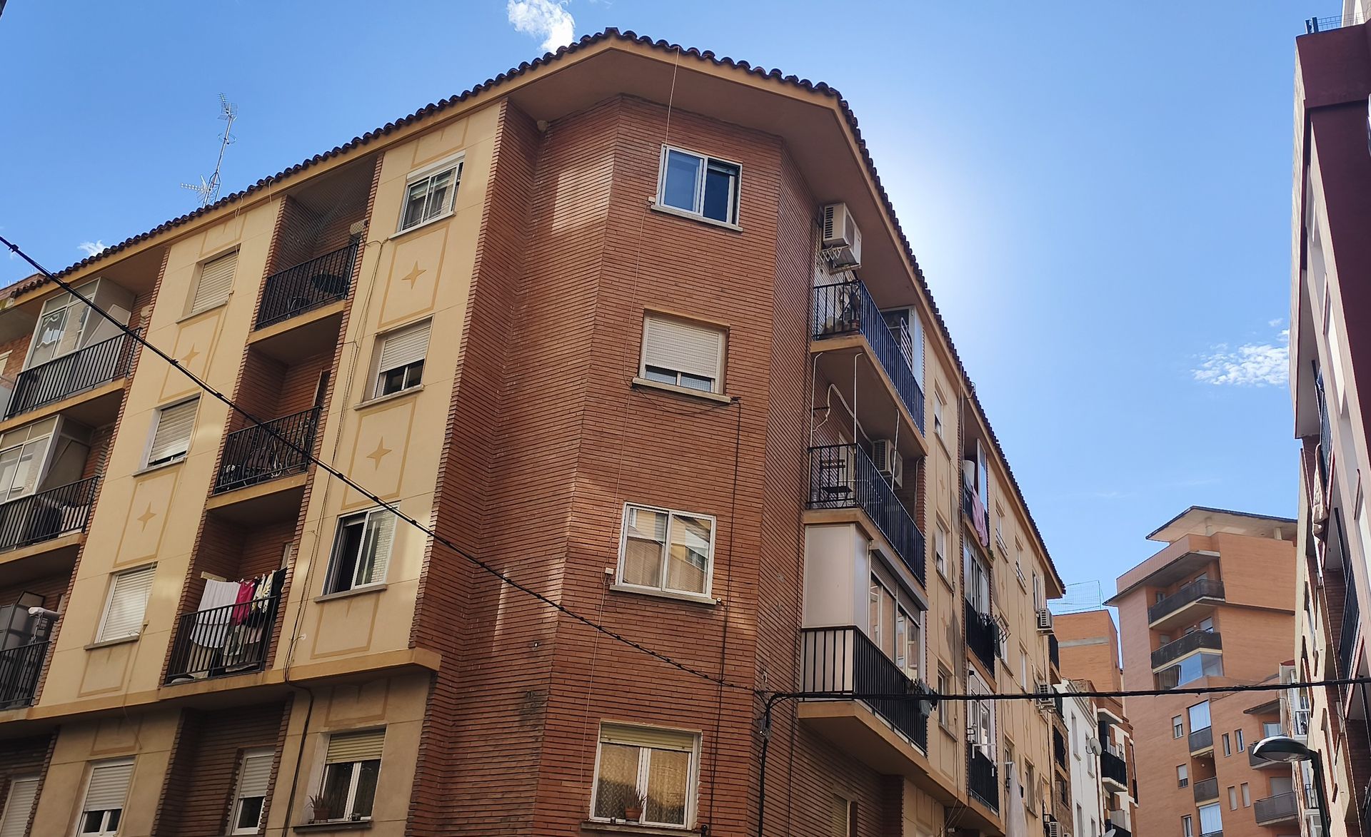 Una hilera de edificios de apartamentos con un cielo azul al fondo.