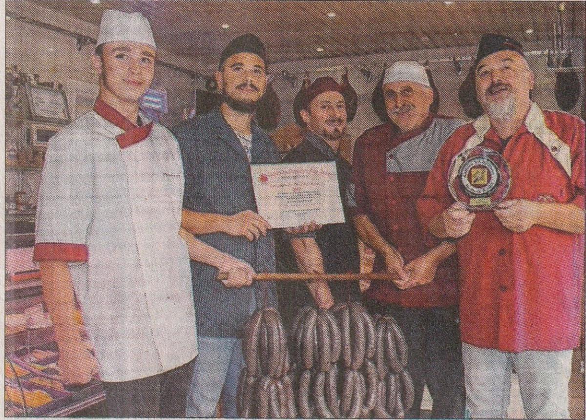 Des personnes qui tiennent un prix et des boudins 